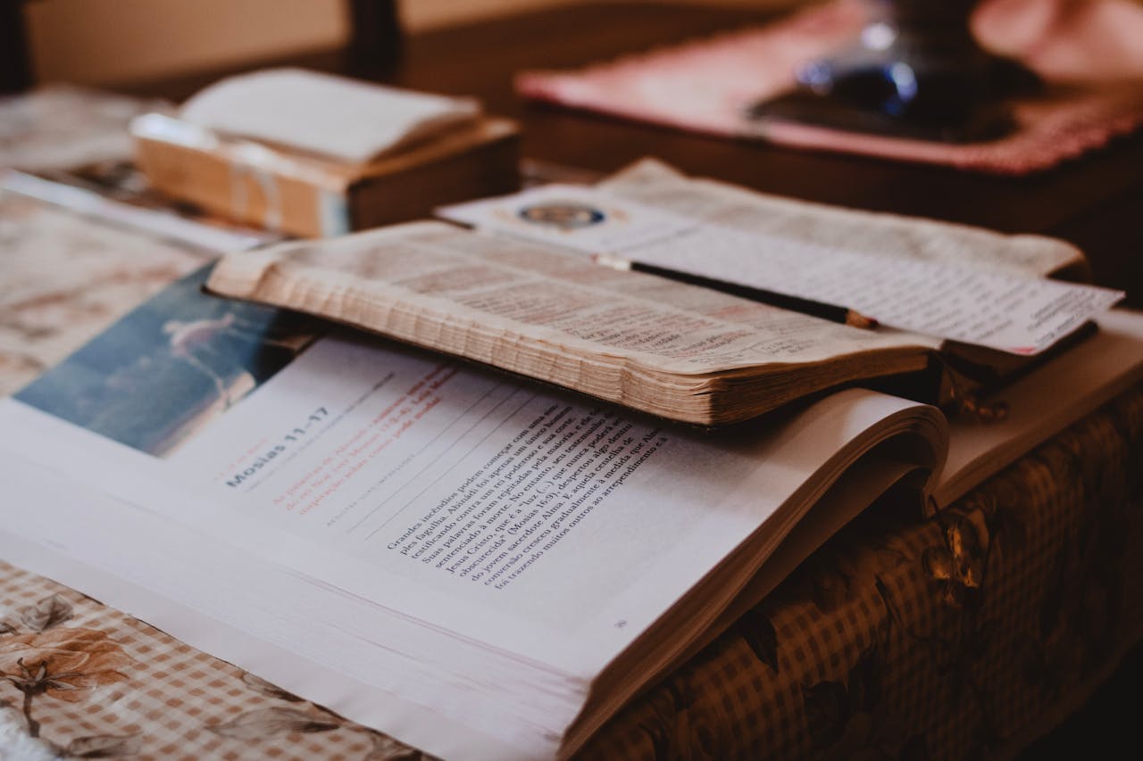 The Art of Drawing Readers In: Your attractive post title goes here Open Bible and notebook on a wooden table with notes and a bookmark, warm lighting.